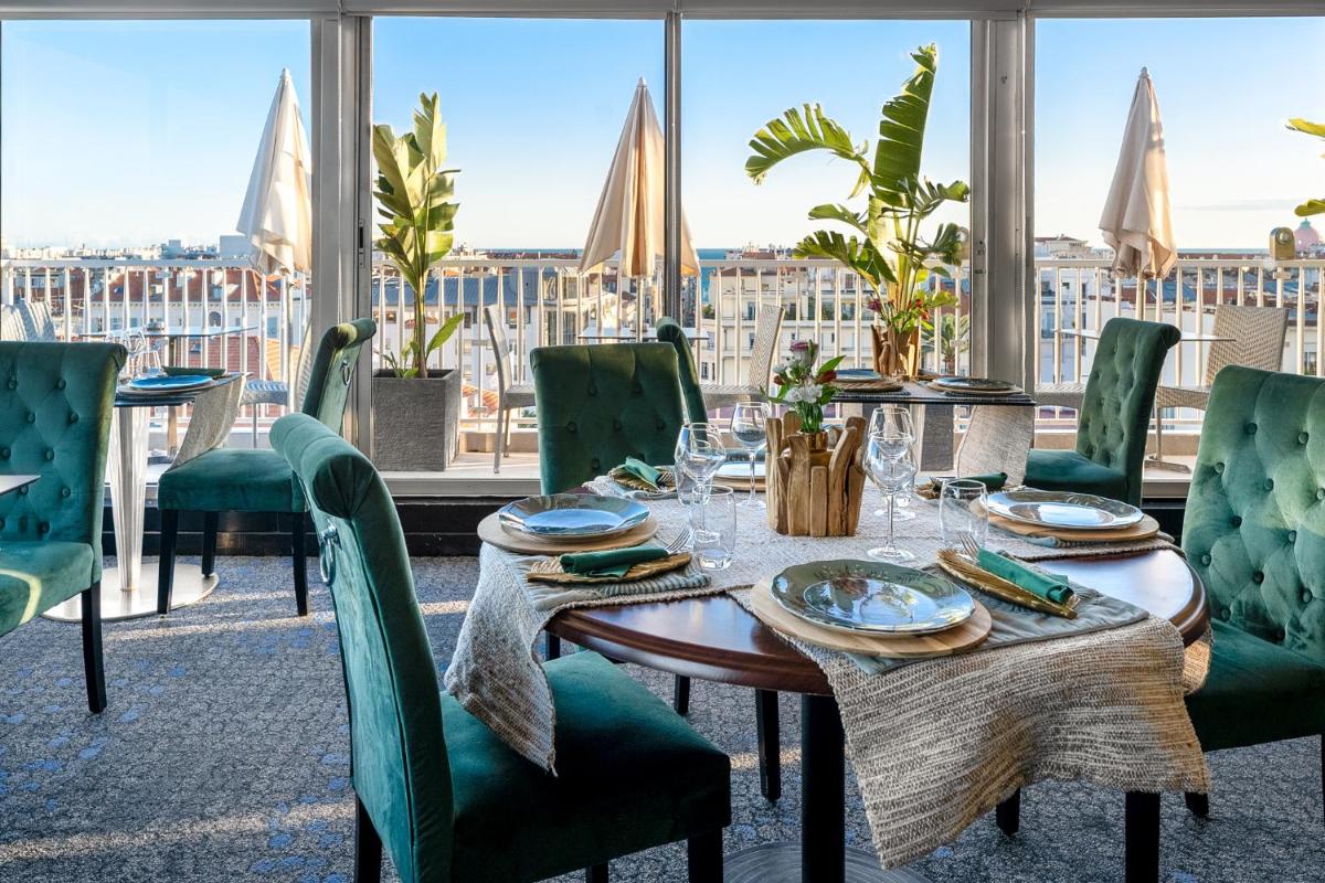 une table dans un restaurant avec vue sur une ville dans l'établissement Splendid Hotel & Spa Nice, à Nice