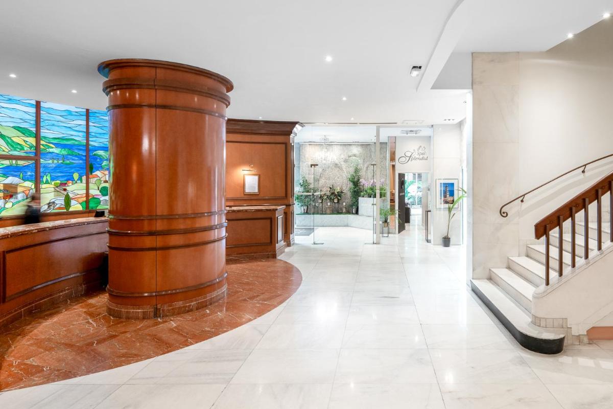 un couloir avec une grande colonne en bois dans un bâtiment dans l'établissement Splendid Hotel & Spa Nice, à Nice 76 autres photos