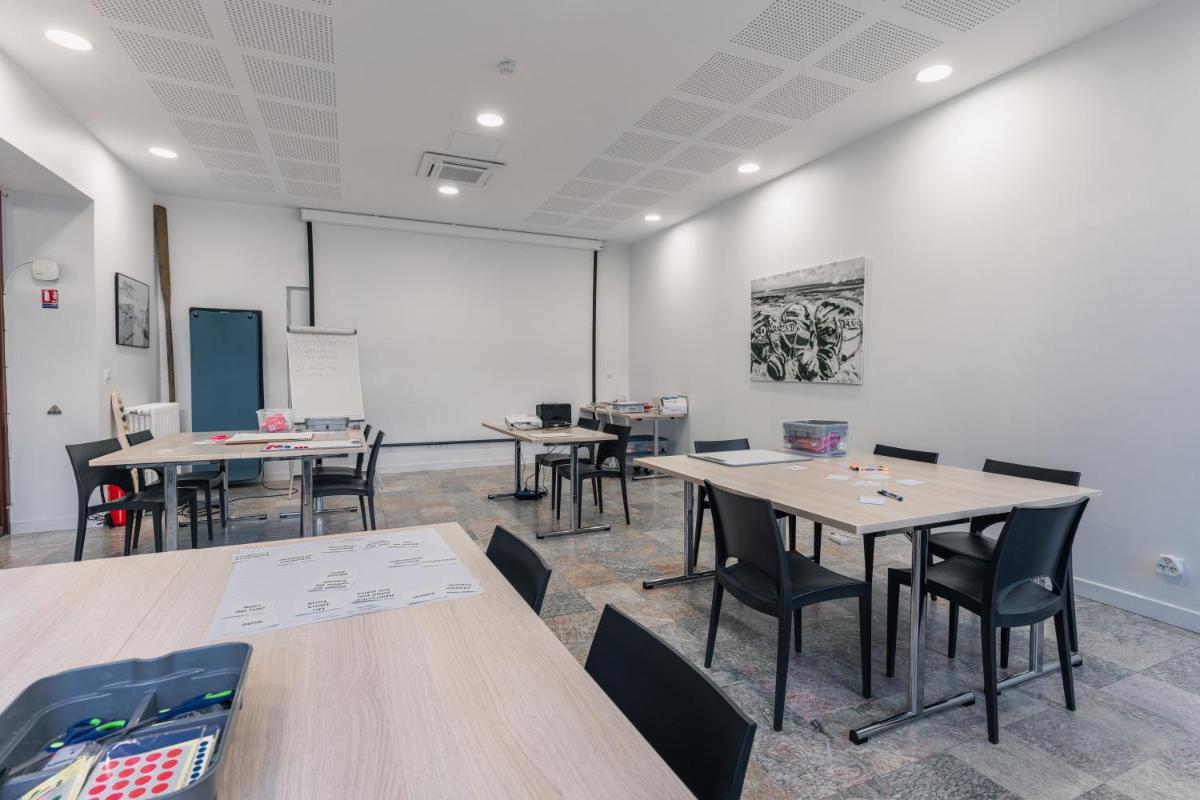 une salle de classe avec des tables et des chaises et un tableau blanc dans l'établissement Hôtel Spa De La Citadelle Lorient, à Port-Louis 75 autres photos
