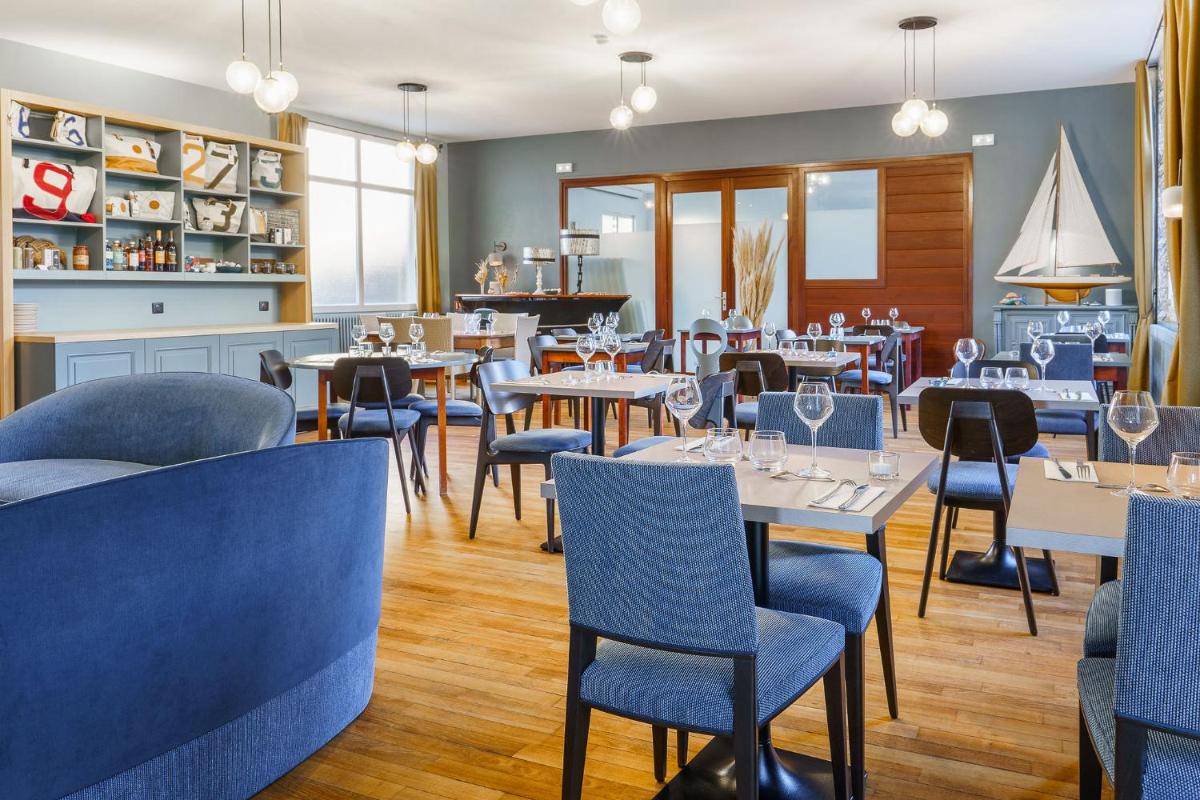 un restaurant avec des tables, des chaises et un piano dans l'établissement Hôtel Spa De La Citadelle Lorient, à Port-Louis