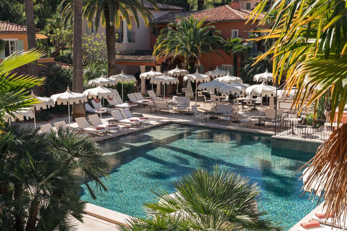 une piscine avec chaises longues et parasols dans l'établissement La Bastide de Saint Tropez, à Saint-Tropez