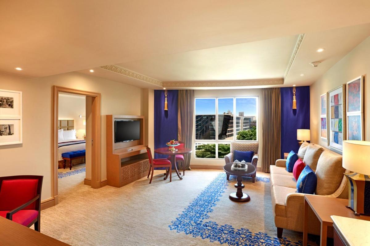 a living room with a couch and a room with a tv at ITC Maratha, a Luxury Collection Hotel, Mumbai in Mumbai