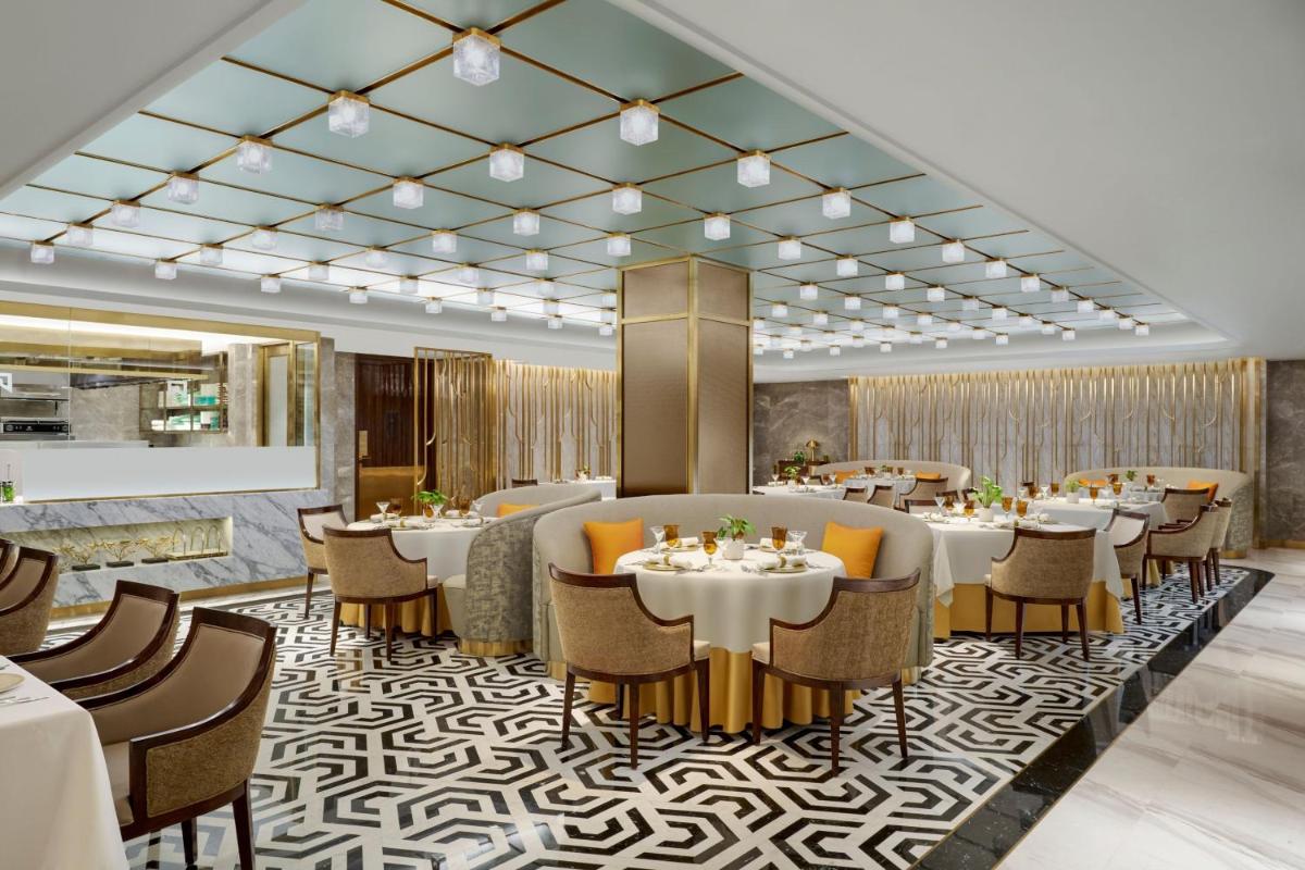 a restaurant with tables and chairs in a room at ITC Maratha, a Luxury Collection Hotel, Mumbai in Mumbai