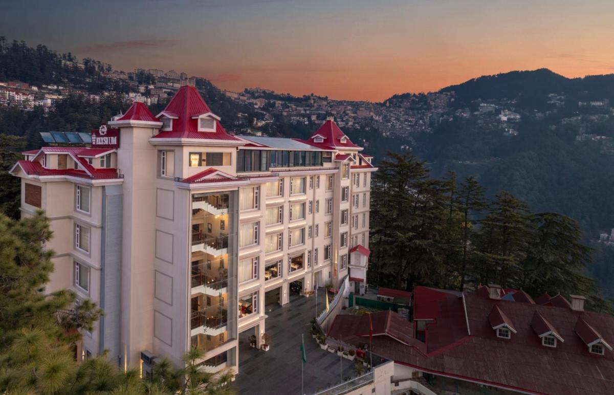 a large white building with red roof at WelcomHeritage Elysium Resort & Spa in Shimla
