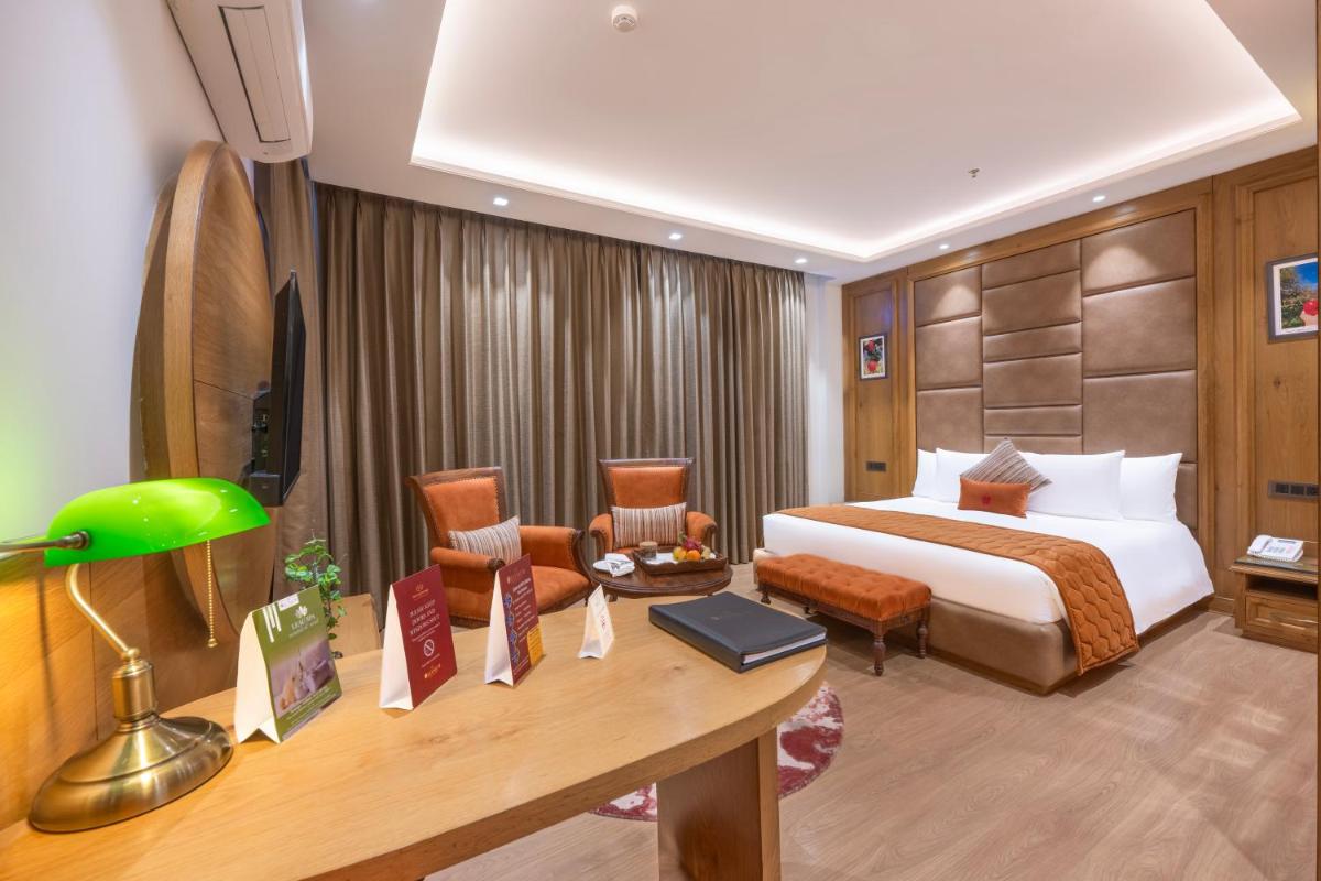 a hotel room with a bed and a desk at WelcomHeritage Elysium Resort & Spa in Shimla