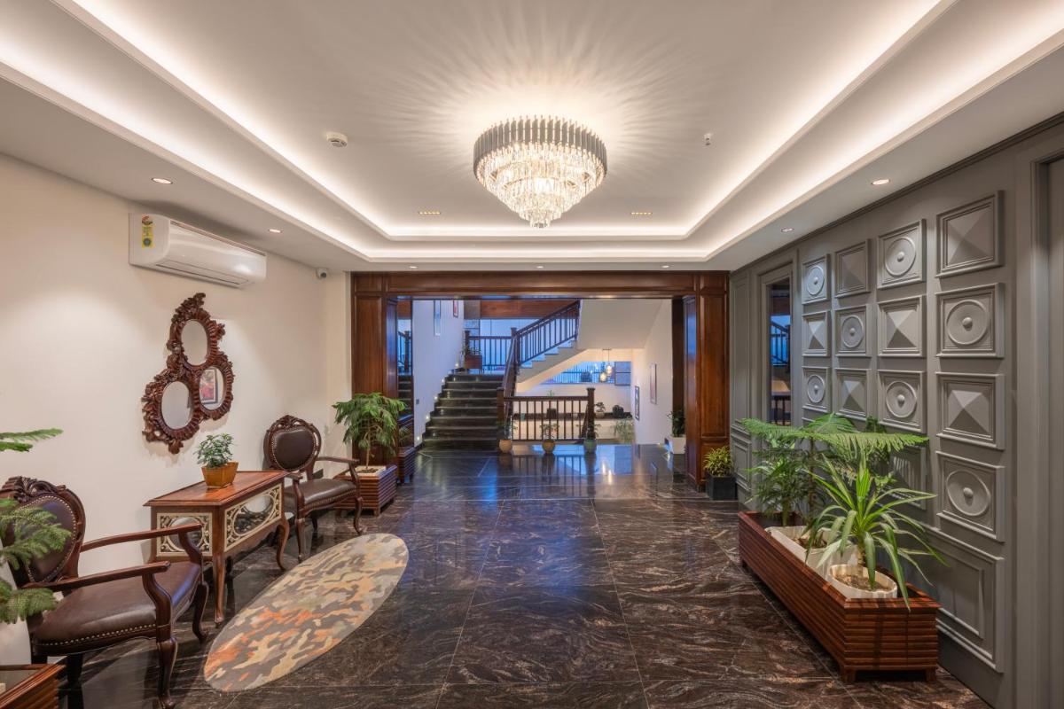 a lobby with chairs and a chandelier at WelcomHeritage Elysium Resort & Spa in Shimla