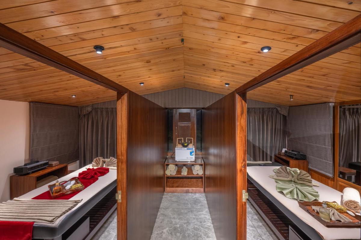 two beds in a room with wooden ceilings at WelcomHeritage Elysium Resort & Spa in Shimla