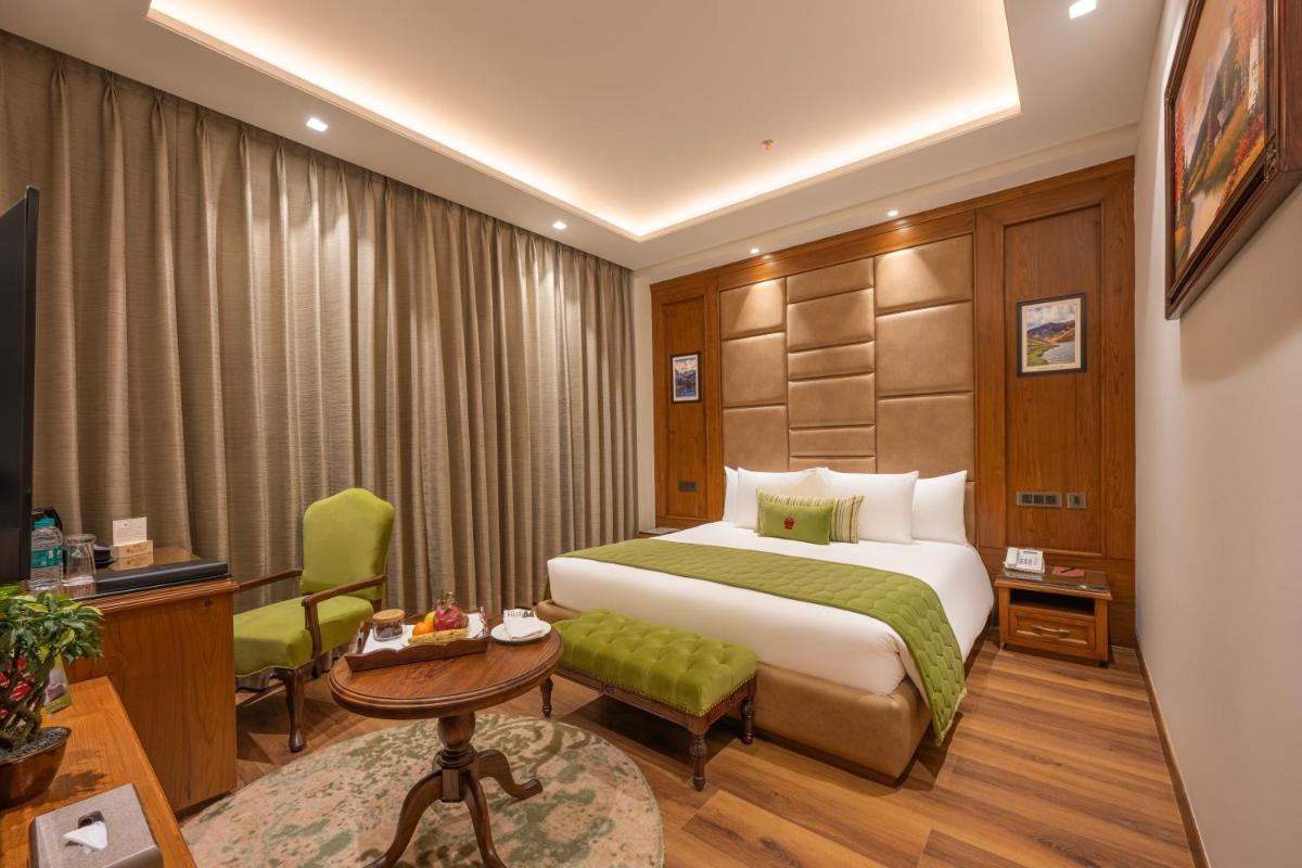 a hotel room with a bed and a desk at WelcomHeritage Elysium Resort & Spa in Shimla