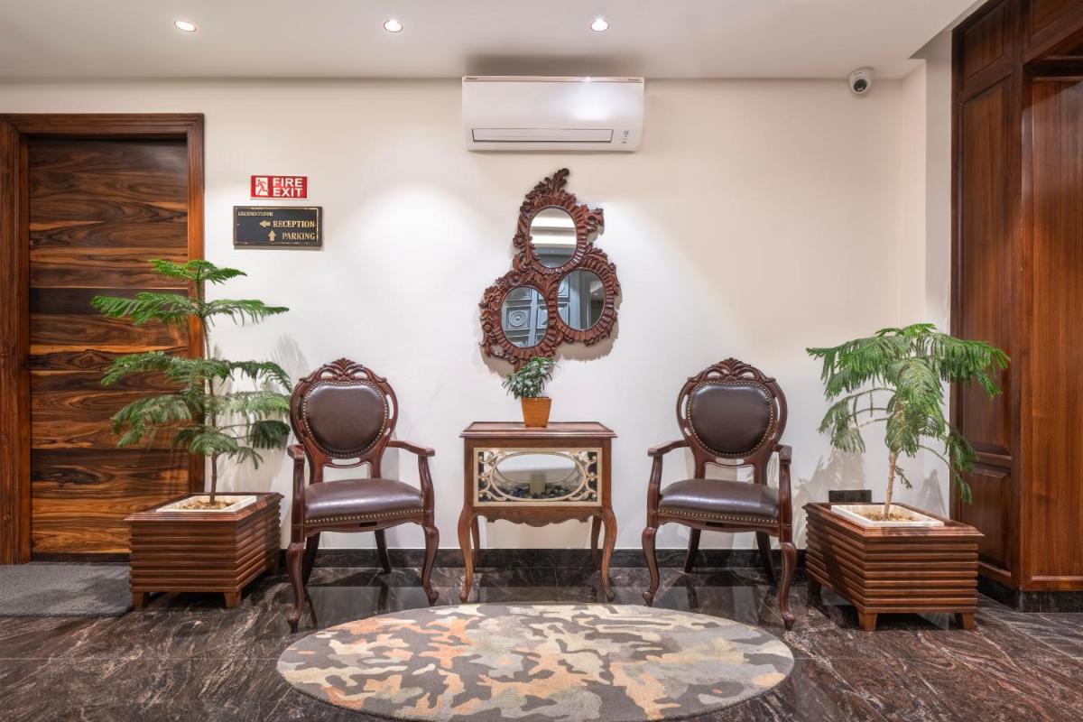 a lobby with two chairs and a mirror on a wall at WelcomHeritage Elysium Resort & Spa in Shimla