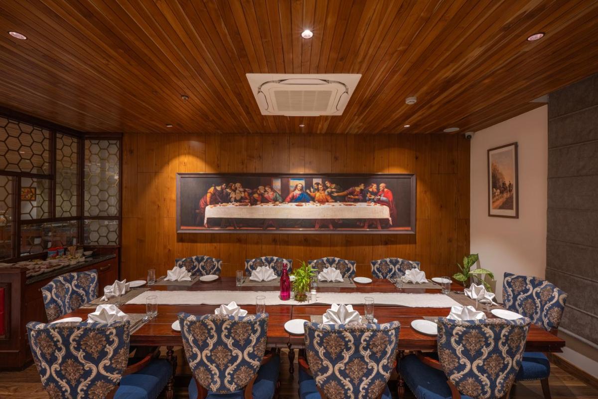a dining room with a table with chairs and a cake at WelcomHeritage Elysium Resort & Spa in Shimla
