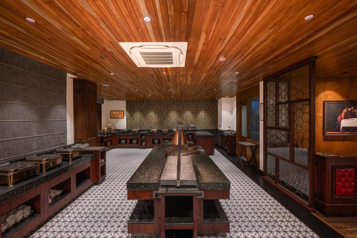 a dining room with wooden ceilings and wooden tables at WelcomHeritage Elysium Resort & Spa in Shimla