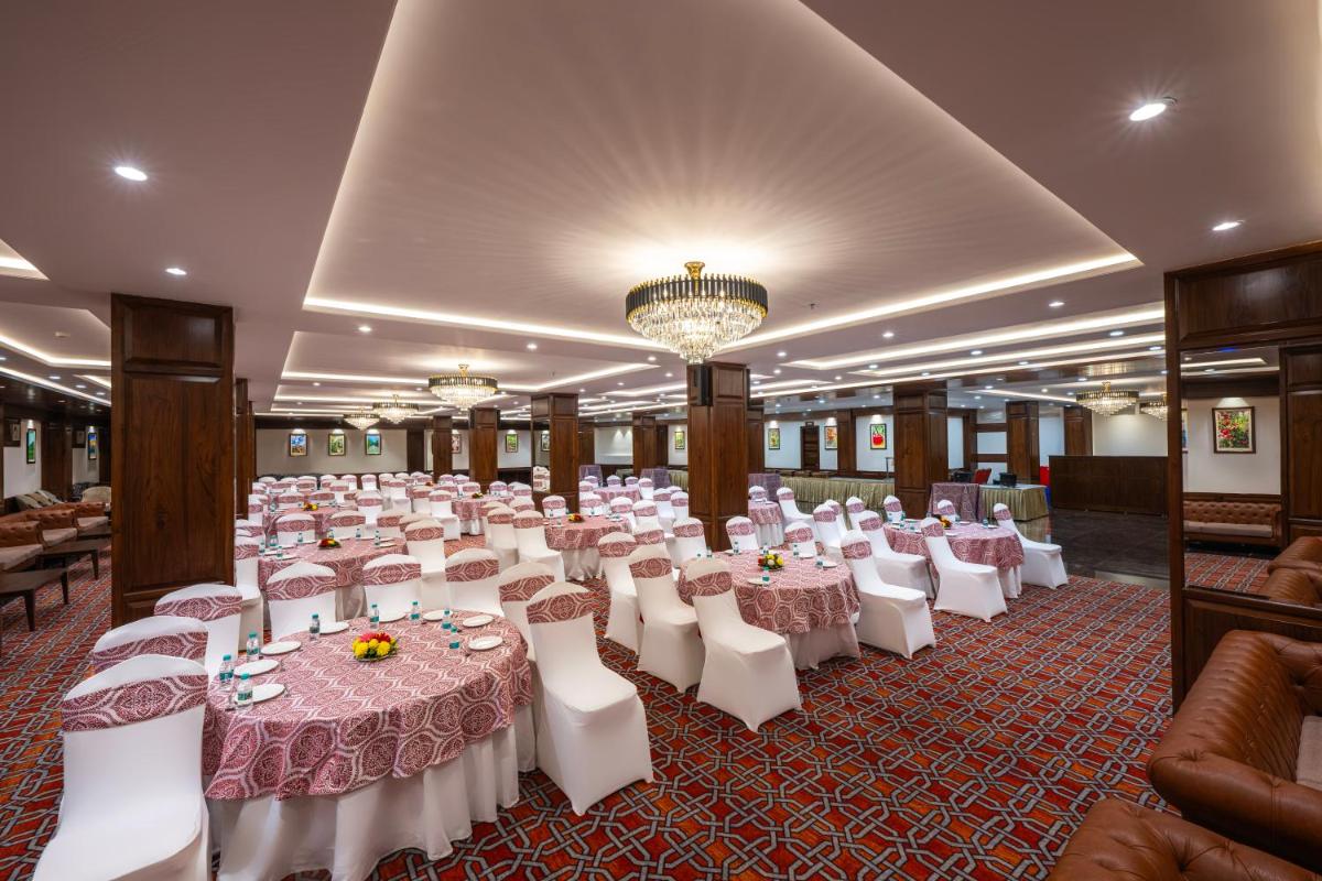 a banquet hall with white tables and white chairs at WelcomHeritage Elysium Resort & Spa in Shimla