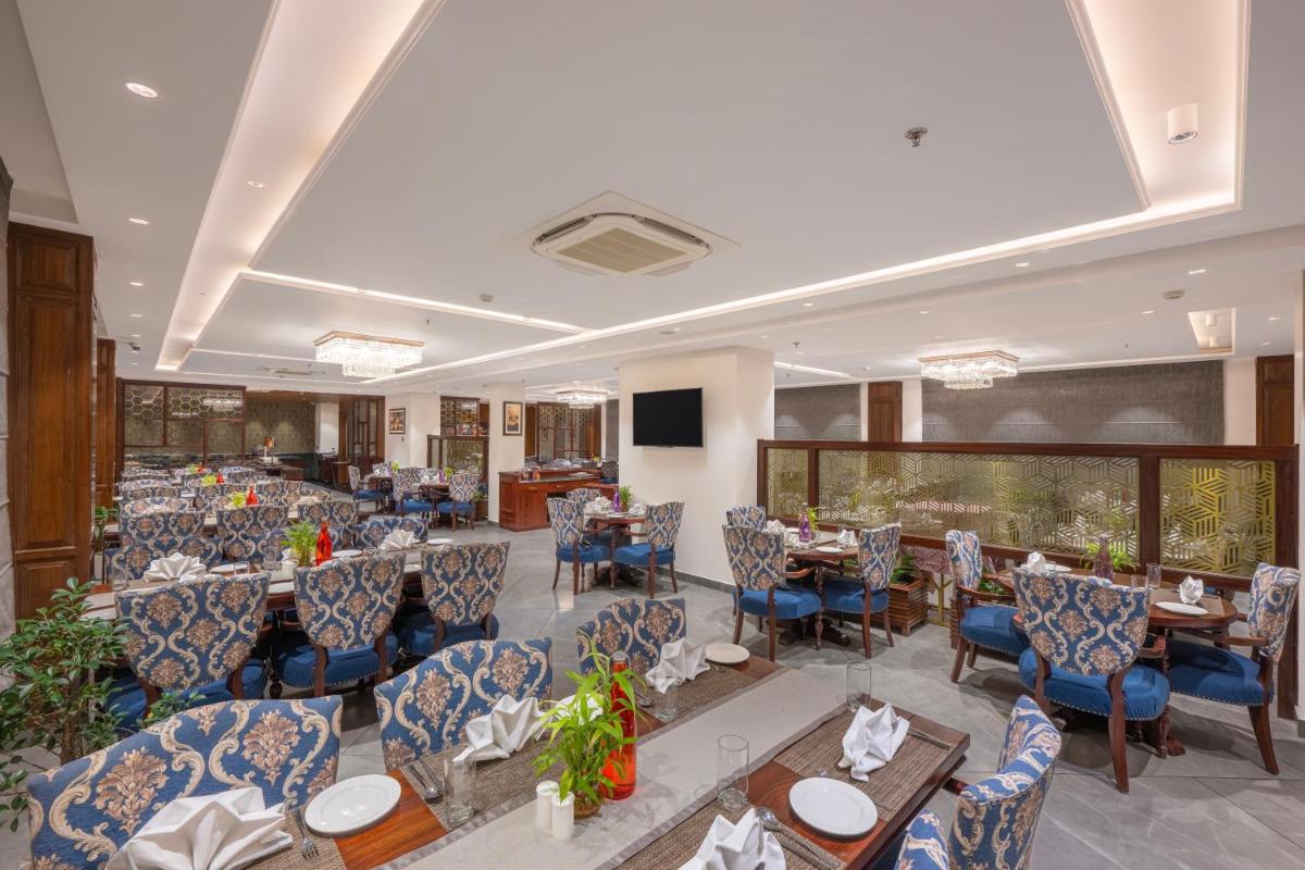 a banquet hall with tables and chairs and a television at WelcomHeritage Elysium Resort & Spa in Shimla
