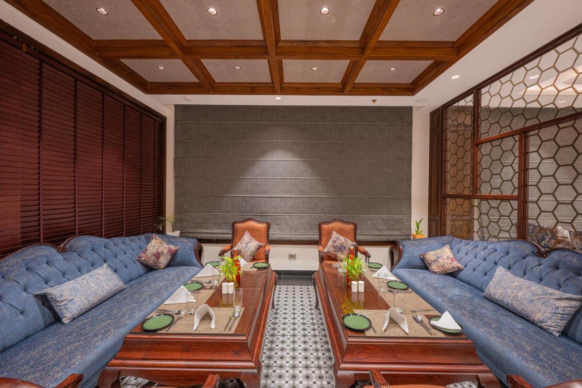 a living room with blue couches and a table at WelcomHeritage Elysium Resort & Spa in Shimla