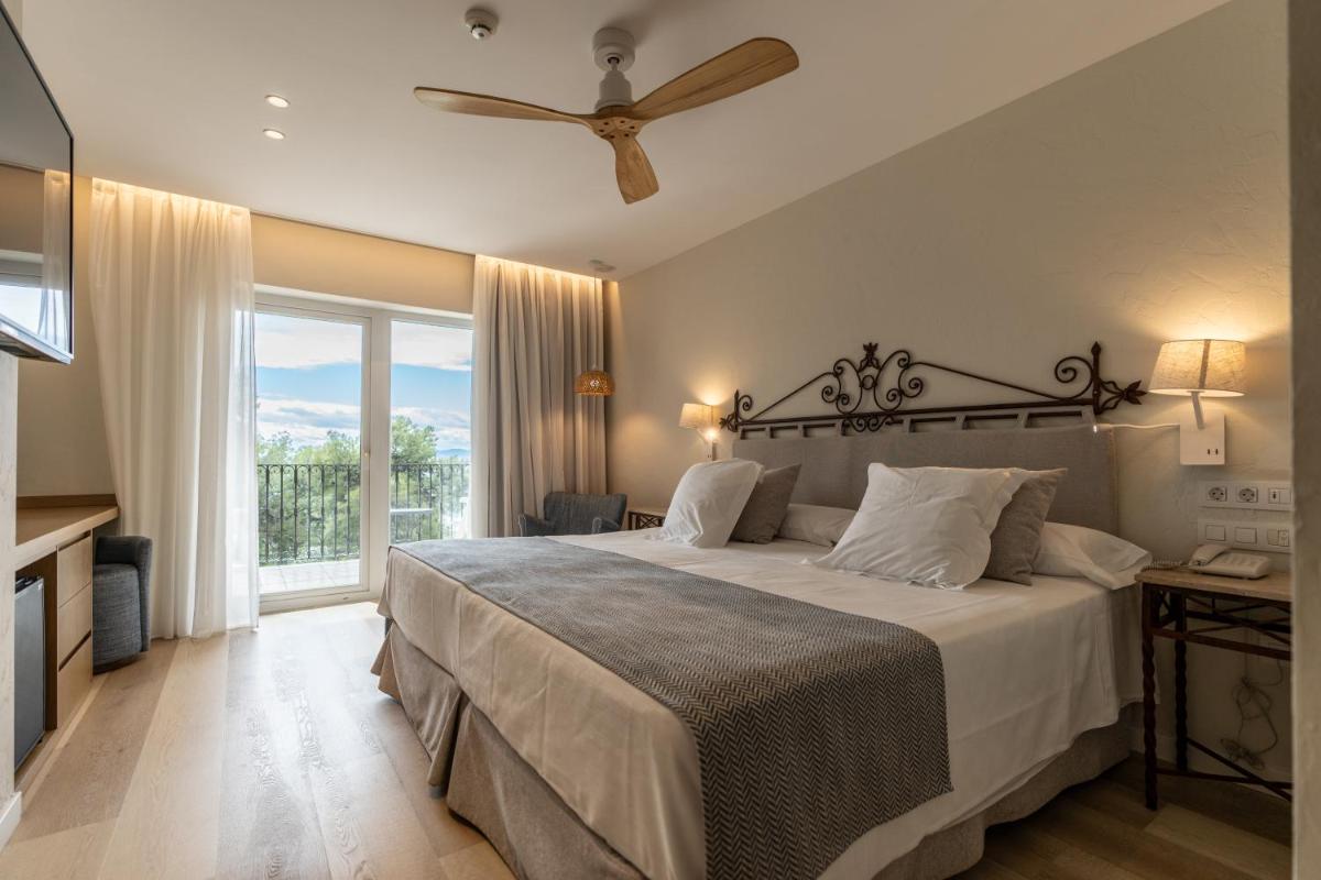 Un dormitorio con una cama grande con ventilador de techo. en PALASIET Wellness Clinic&Thalasso 4 SUP, en Benicàssim 31 fotos más