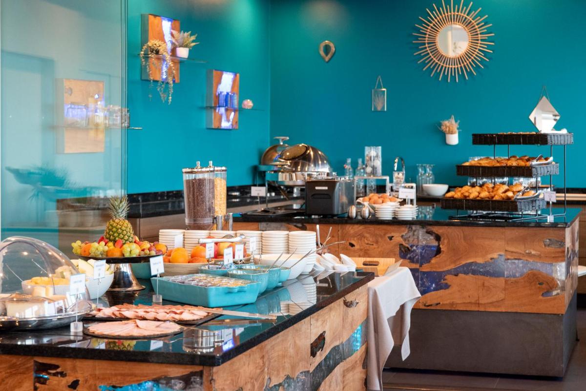 un buffet avec de la nourriture sur un mur bleu dans l'établissement Côté Thalasso Hôtel & Spa Marin, à Banyuls-sur-Mer 62 autres photos