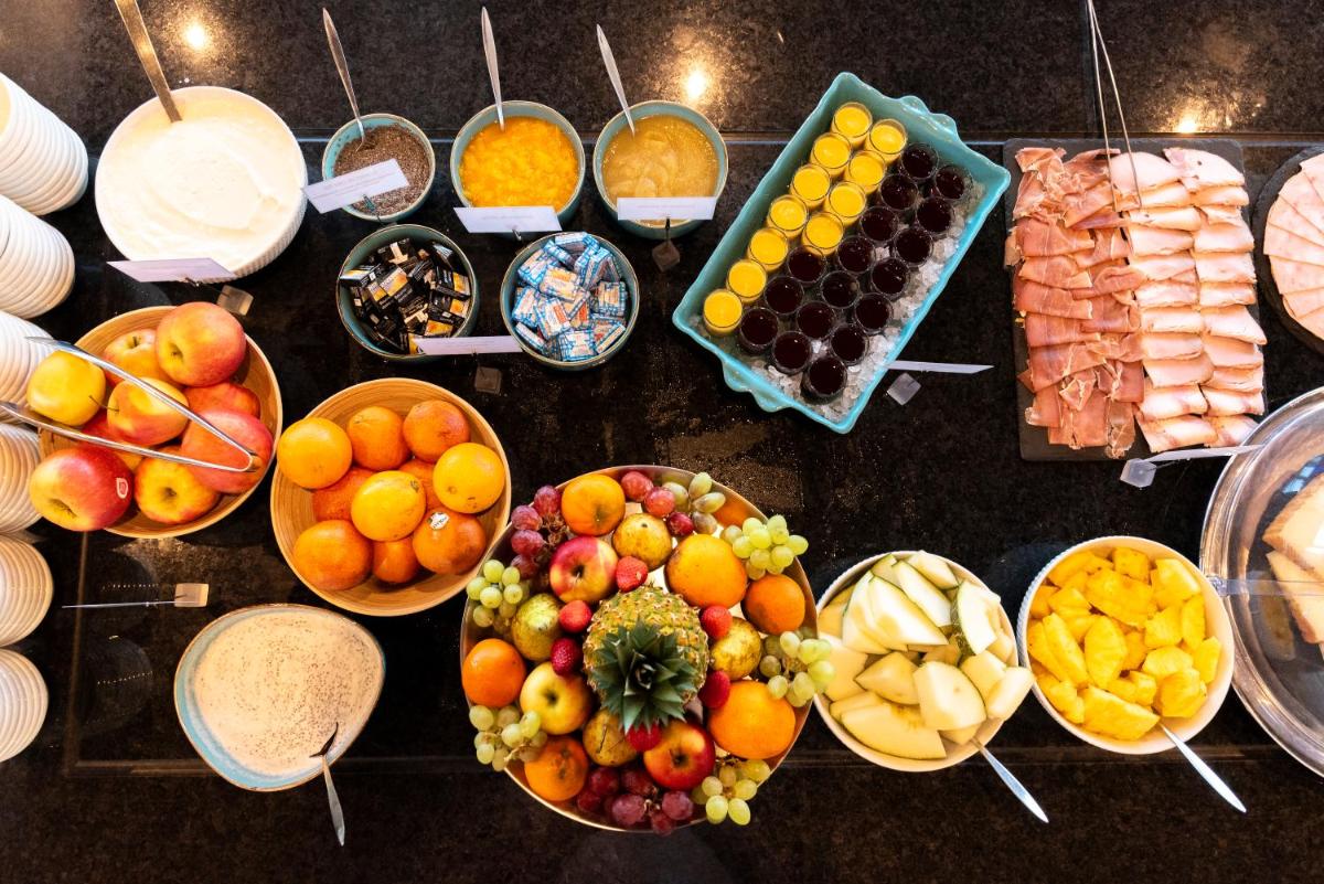 une table avec des coupes de fruits et des assiettes de nourriture dans l'établissement Côté Thalasso Hôtel & Spa Marin, à Banyuls-sur-Mer
