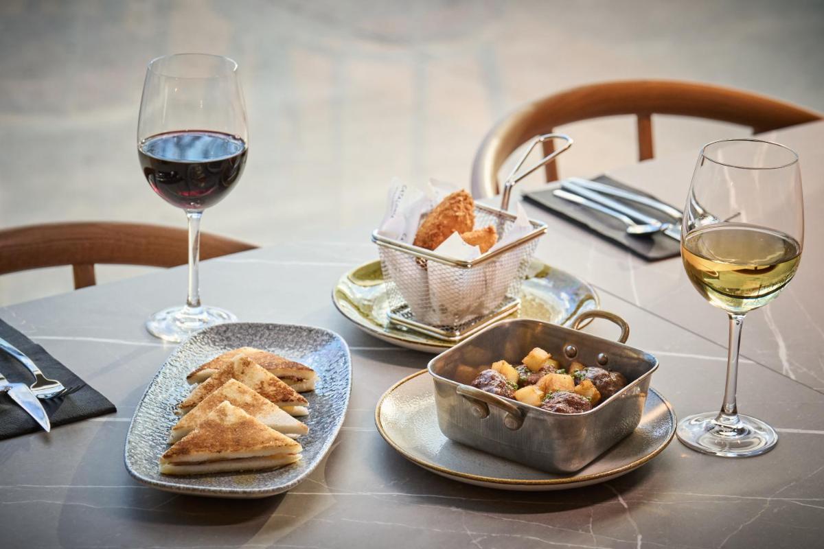 una mesa con dos copas de vino y un plato de comida en Catalonia La Maquinista, en Barcelona