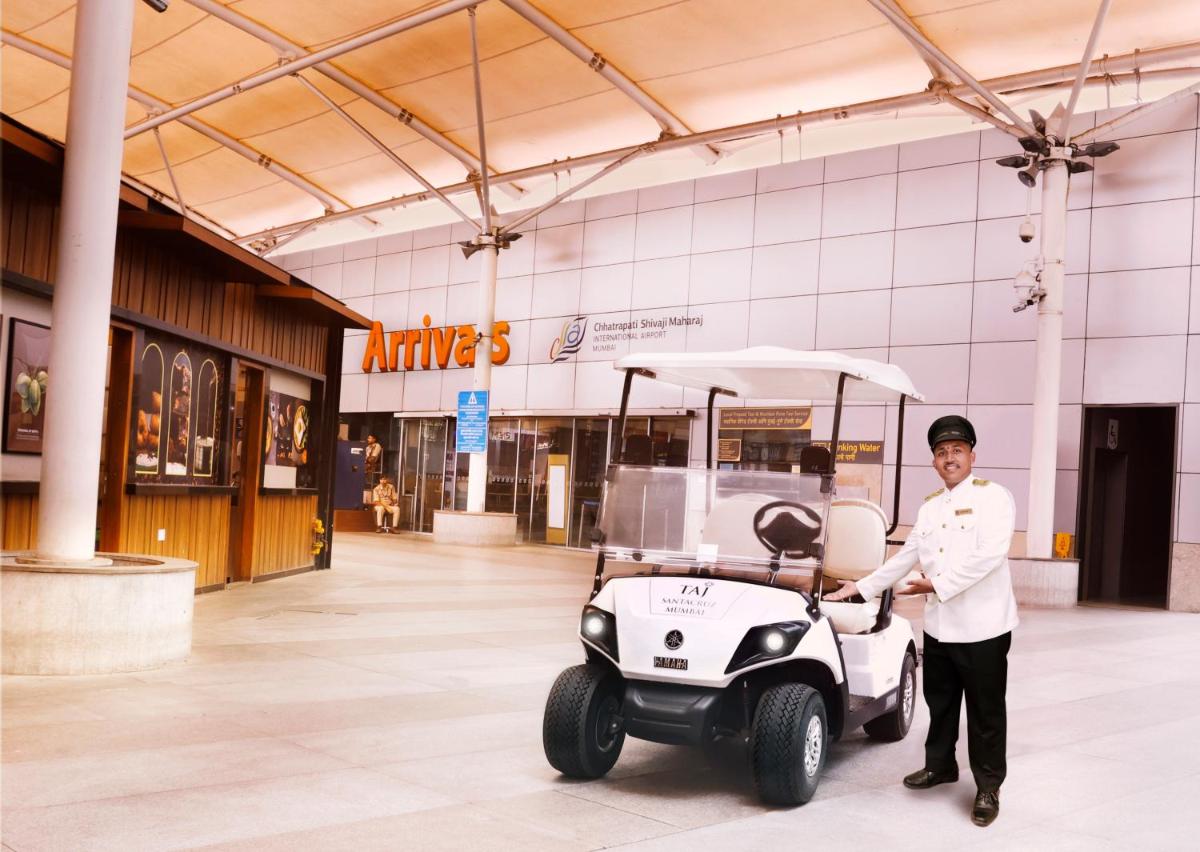 a man is standing next to a golf cart at Taj Santacruz in Mumbai