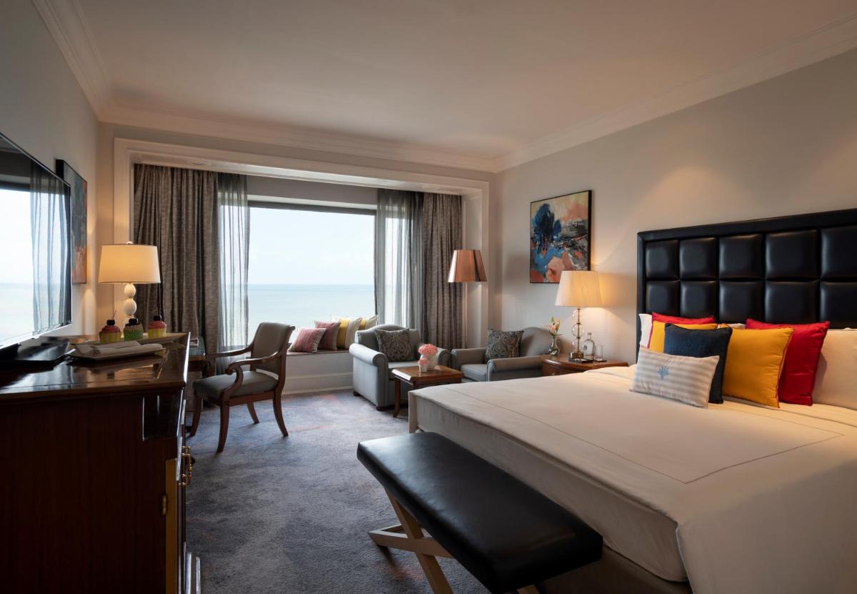 a bedroom with a large bed and a living room at Taj Lands End in Mumbai a bedroom with a large bed and a living room at Taj Lands End in Mumbai