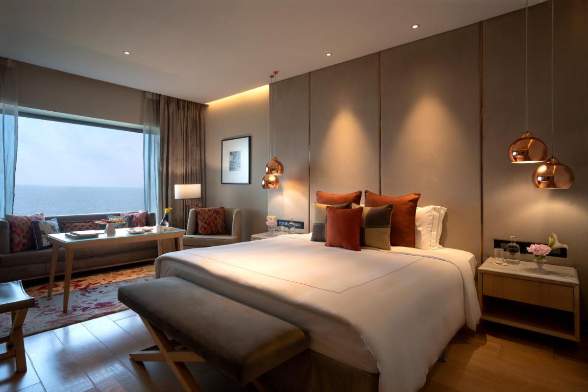 a bedroom with a large bed and a living room at Taj Lands End in Mumbai a bedroom with a large bed and a living room at Taj Lands End in Mumbai