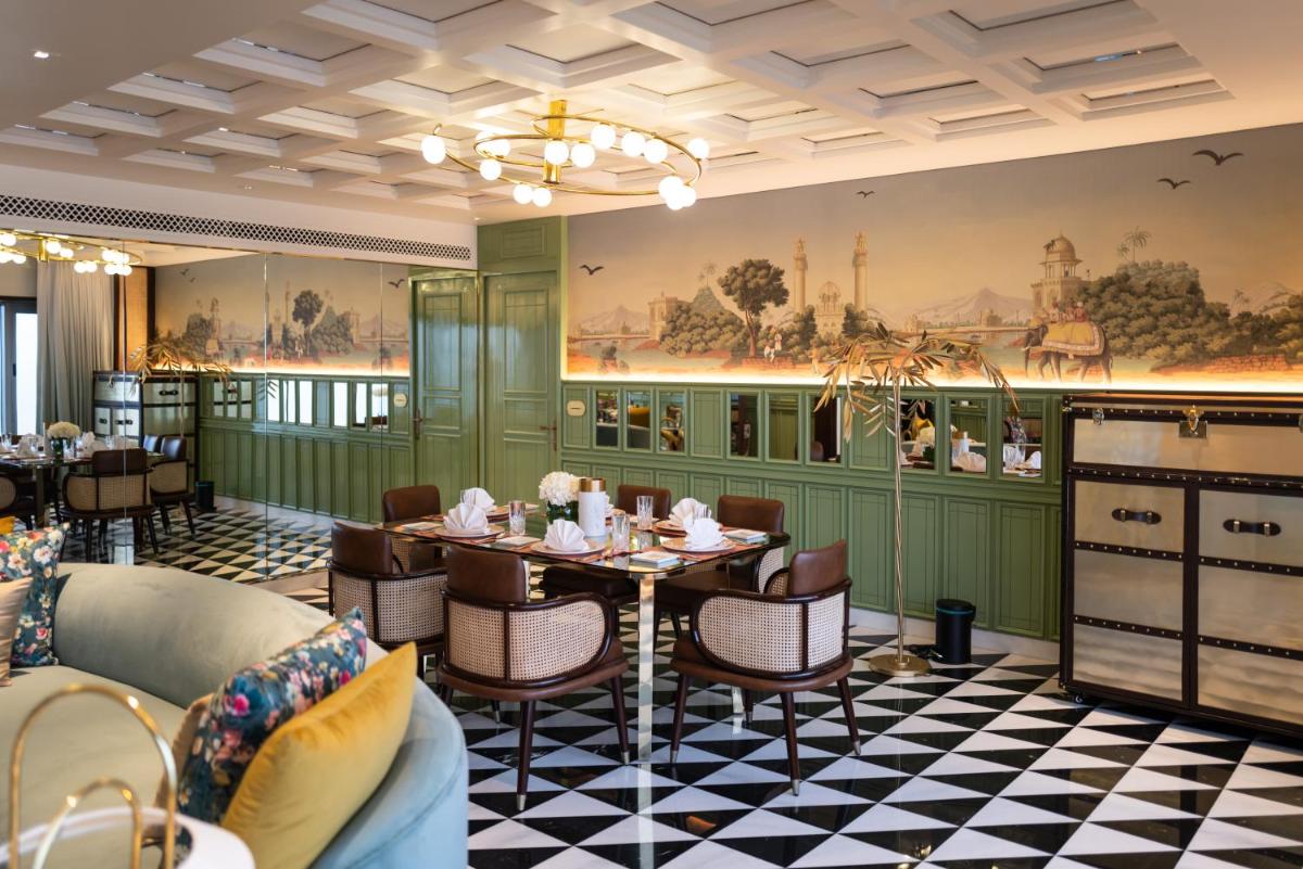 a dining room with tables and chairs and a mural at Taj Lands End in Mumbai a dining room with tables and chairs and a mural at Taj Lands End in Mumbai