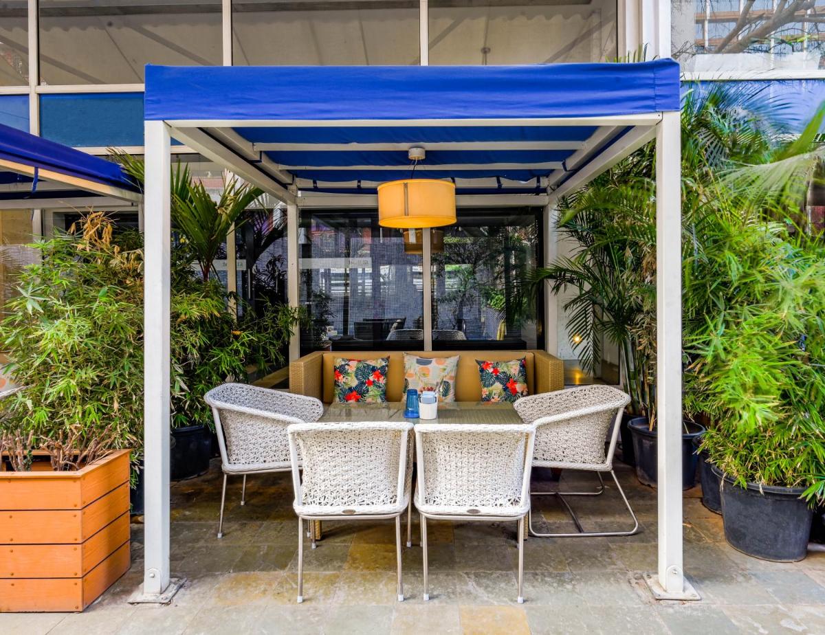 a table and chairs under a blue canopy at The Park Bangalore, MG Road in Bengaluru a table and chairs under a blue canopy at The Park Bangalore, MG Road in Bengaluru