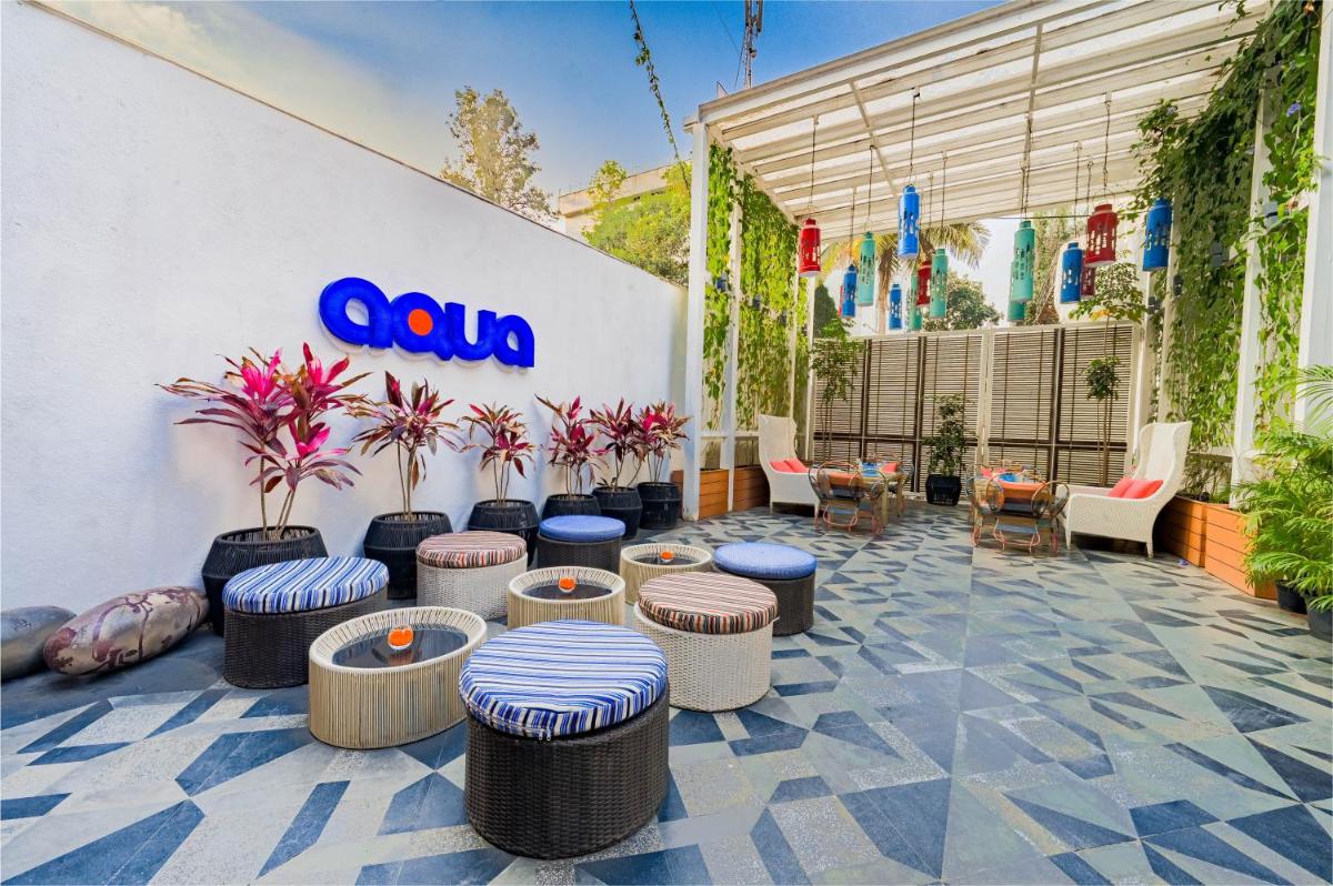 a patio with stools and tables and a sign on a wall at The Park Bangalore, MG Road in Bengaluru a patio with stools and tables and a sign on a wall at The Park Bangalore, MG Road in Bengaluru