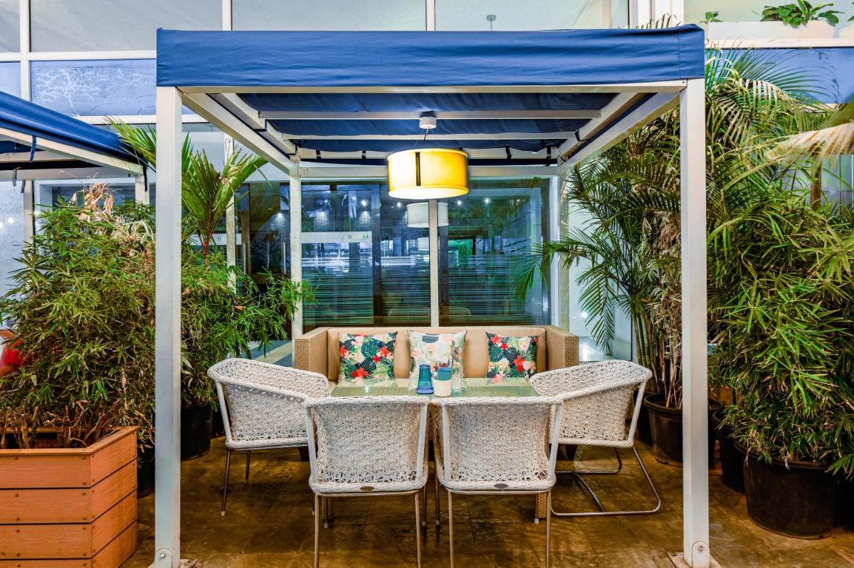 a gazebo with a table and chairs and plants at The Park Bangalore, MG Road in Bengaluru a gazebo with a table and chairs and plants at The Park Bangalore, MG Road in Bengaluru