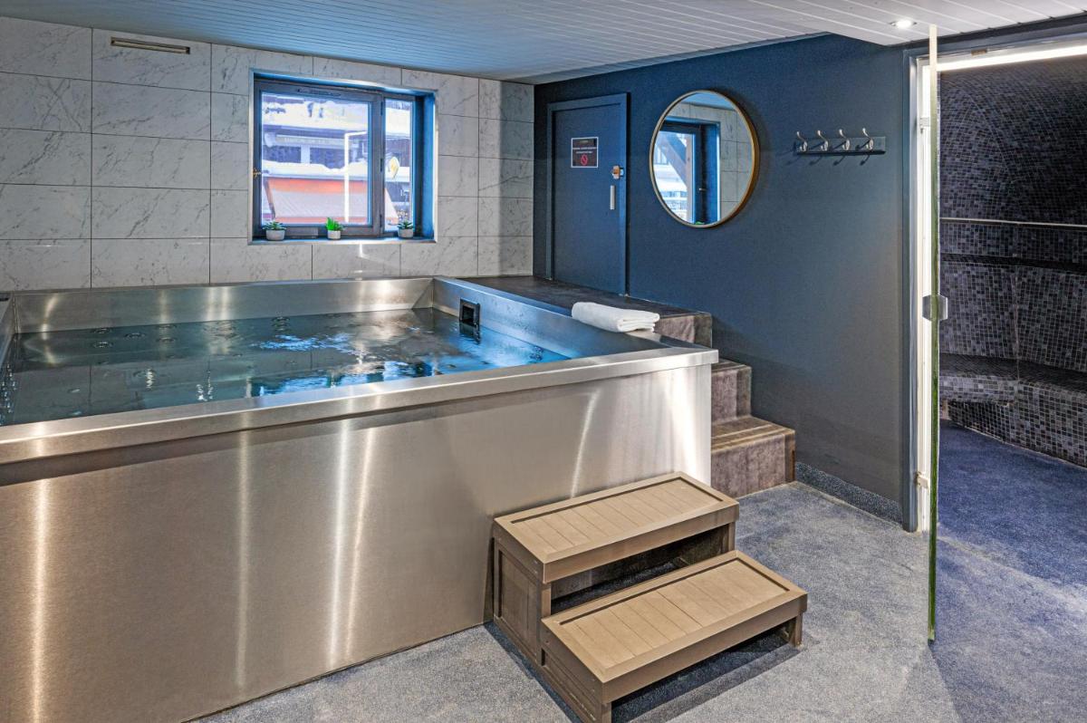 une grande salle de bain avec une baignoire et un lavabo dans l'établissement Hôtel Le Levanna by Les Etincelles, à Tignes