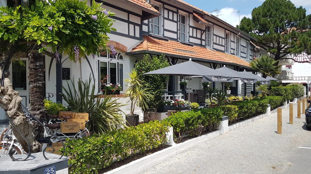 un bâtiment avec des parasols et des plantes dans une rue dans l'établissement Hotel Ty Gwenn La Baule, à La Baule