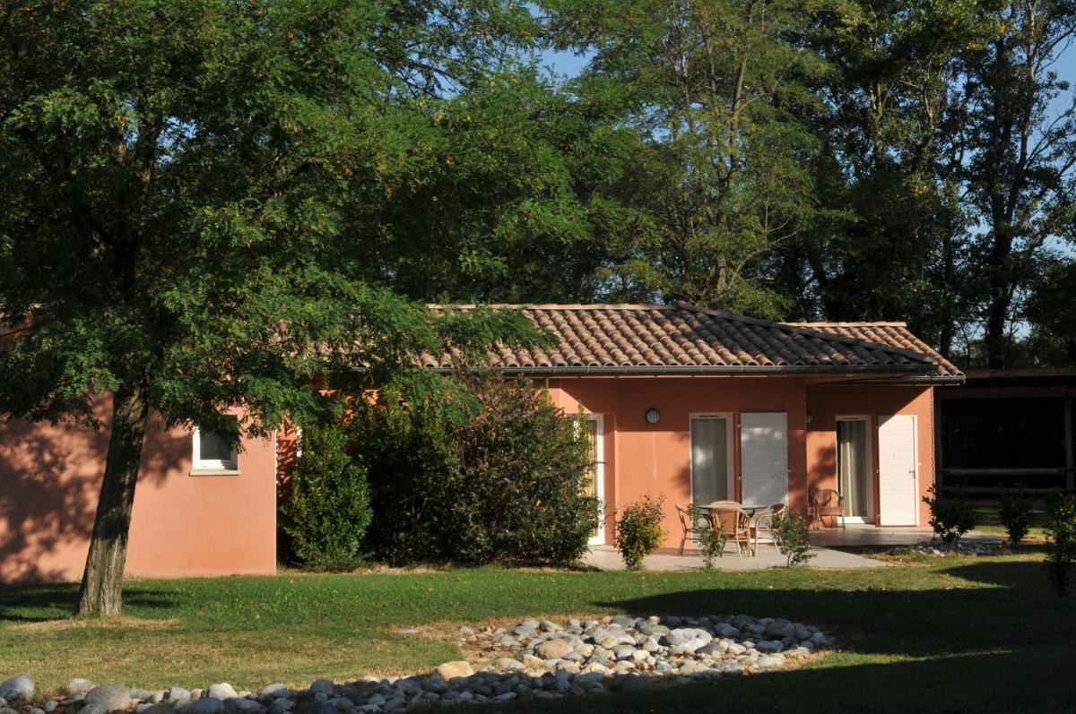 une petite maison avec un arbre et un jardin dans l'établissement Domaine d'Agrippa Valence, à Châteauneuf-sur-Isère