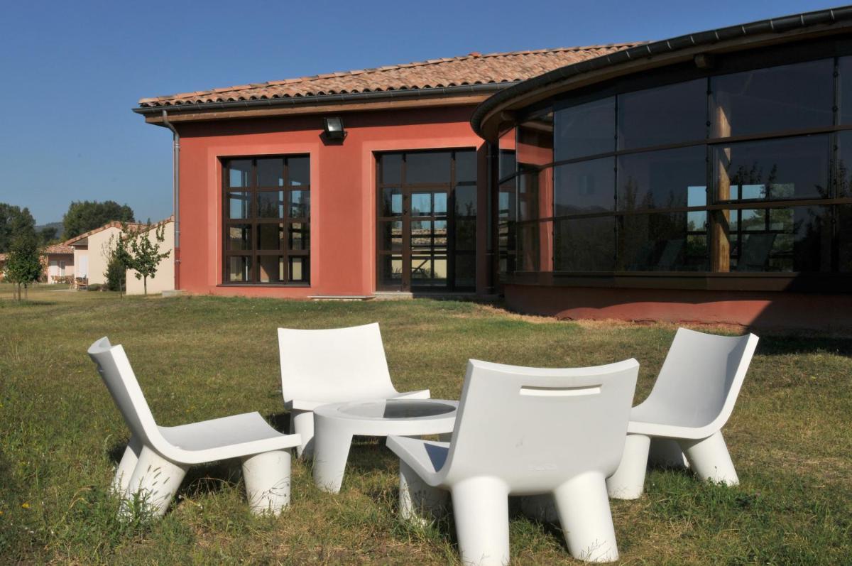 un groupe de chaises blanches devant une maison dans l'établissement Domaine d'Agrippa Valence, à Châteauneuf-sur-Isère