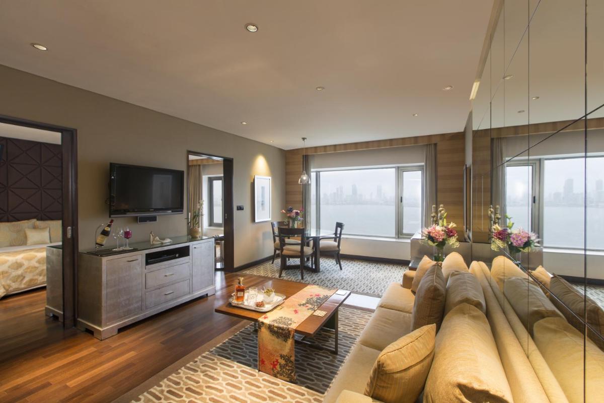 a living room with a couch and a tv at Taj Lands End in Mumbai a living room with a couch and a tv at Taj Lands End in Mumbai
