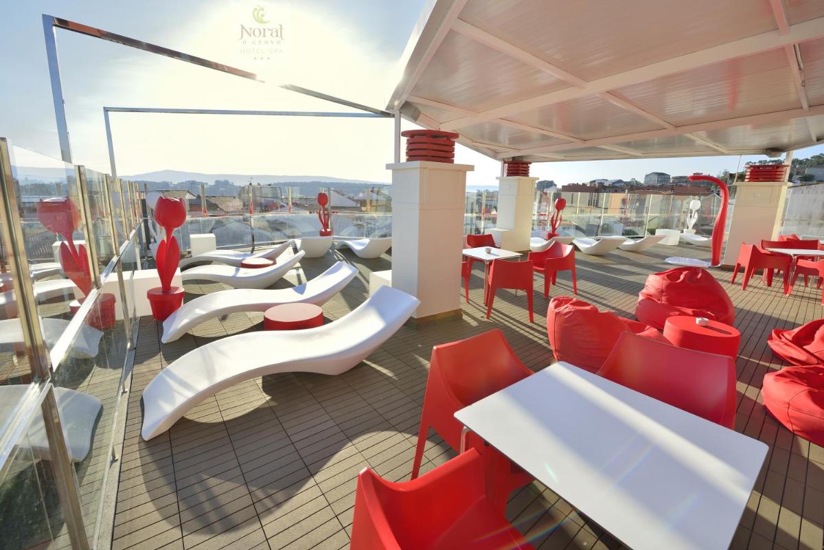 un balcón con sillas rojas y mesas en un barco en Hotel Spa Norat O Grove 3* Superior, en O Grove