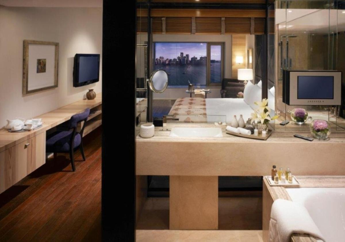 a bathroom with a large tub and a sink in a room at Taj Lands End in Mumbai a bathroom with a large tub and a sink in a room at Taj Lands End in Mumbai
