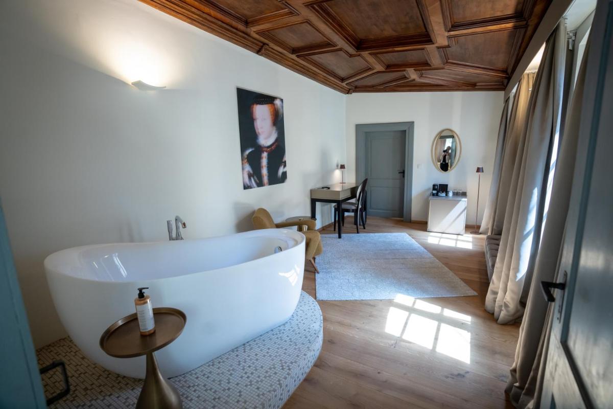 ein Bad mit einer weißen Badewanne in einem Zimmer in der Unterkunft Maxim Suites by Elias Holl in Augsburg