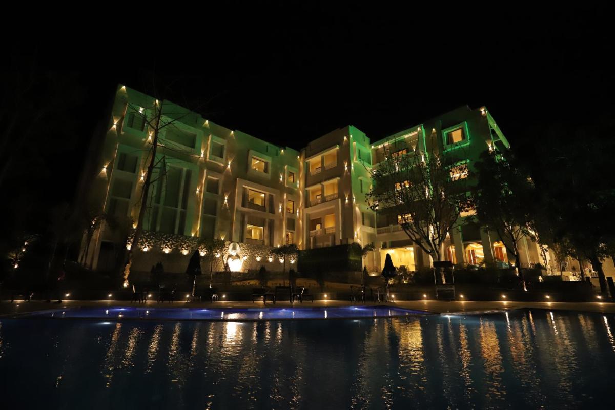 a large building with lights in the night at Essentia Luxury Resort & Spa Udaipur in Udaipur