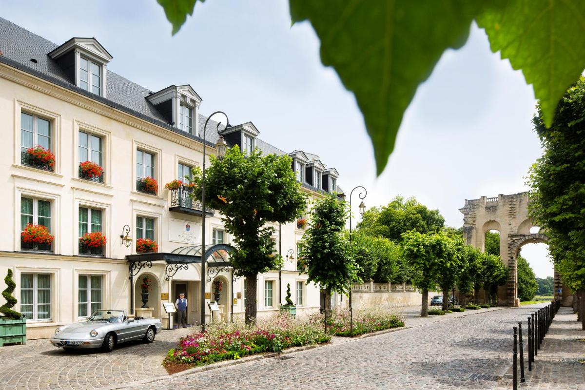 une voiture garée devant un immeuble dans l'établissement Auberge du Jeu de Paume, à Chantilly