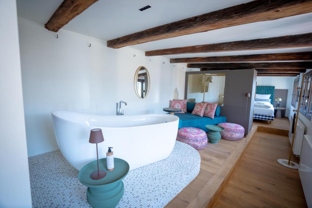 ein Badezimmer mit einer weißen Badewanne und einer Couch in der Unterkunft Maxim Suites by Elias Holl in Augsburg + 37 Fotos