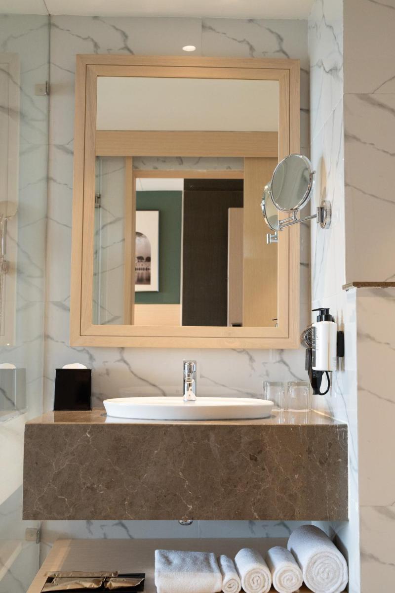 a bathroom with a sink and a mirror at Novotel Jaipur Convention Centre in Jaipur