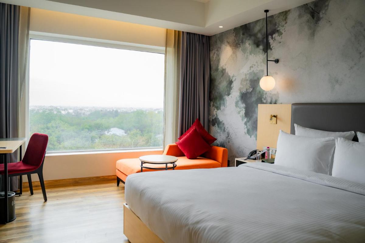 a hotel room with a bed and a window at Novotel Jaipur Convention Centre in Jaipur