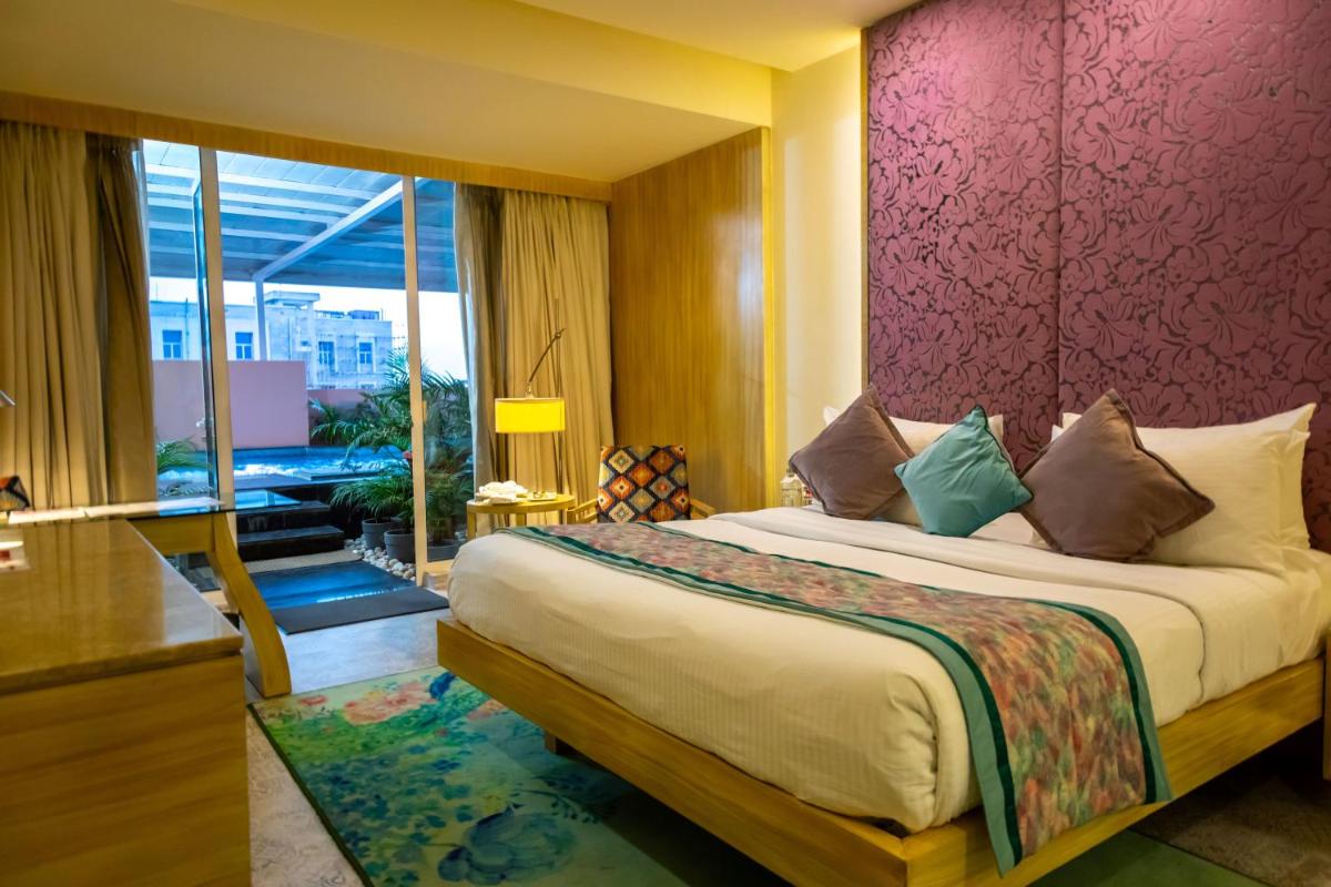 a bedroom with a large bed with a purple wall at Hotel Royal Orchid Jaipur, Tonk Road in Jaipur
