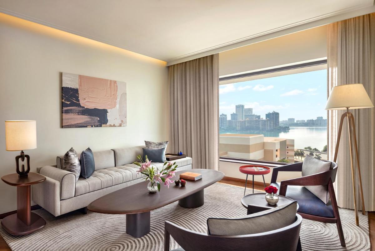 a living room with a couch and a large window at The Oberoi Mumbai in Mumbai