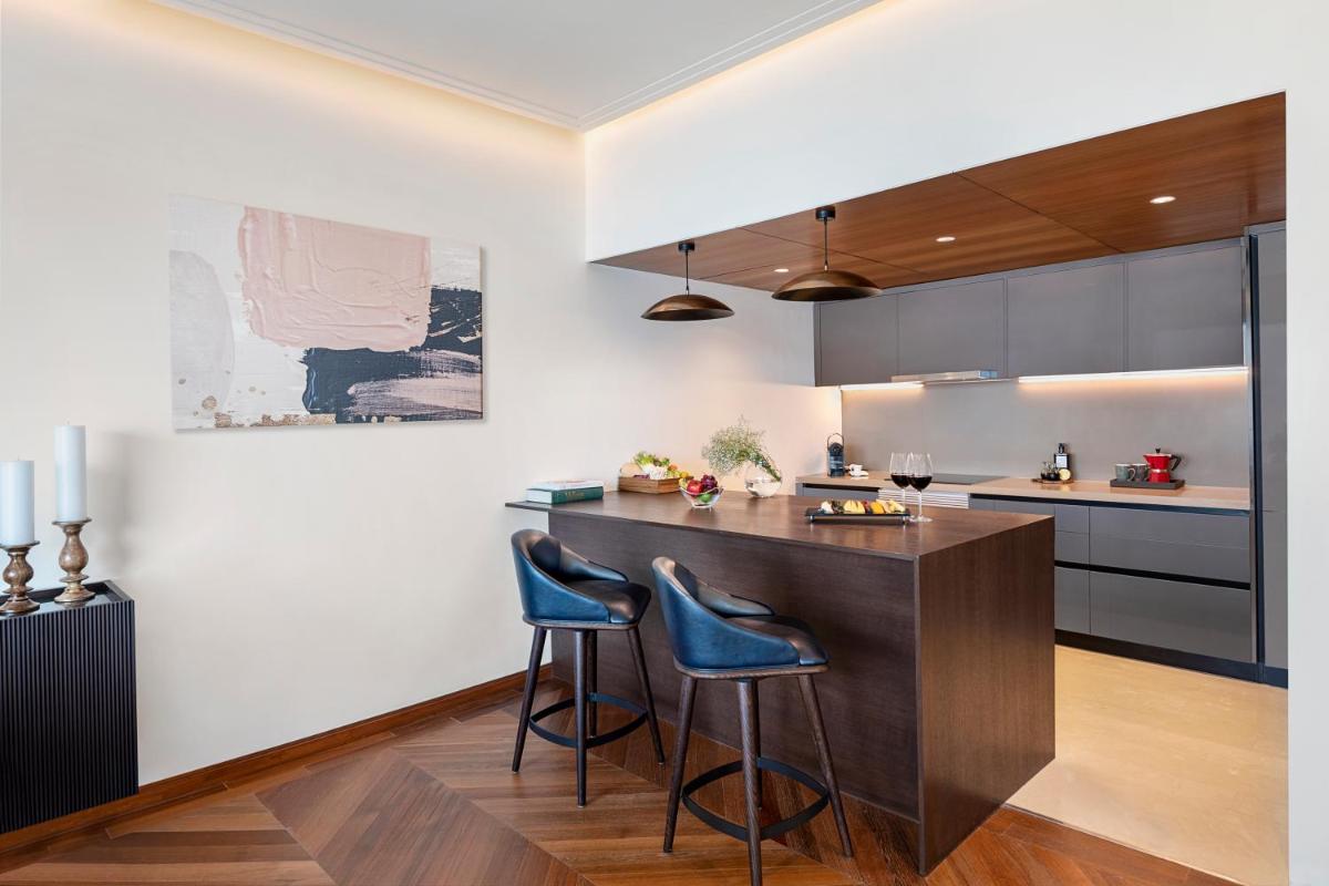 a kitchen with a bar with two blue stools at The Oberoi Mumbai in Mumbai