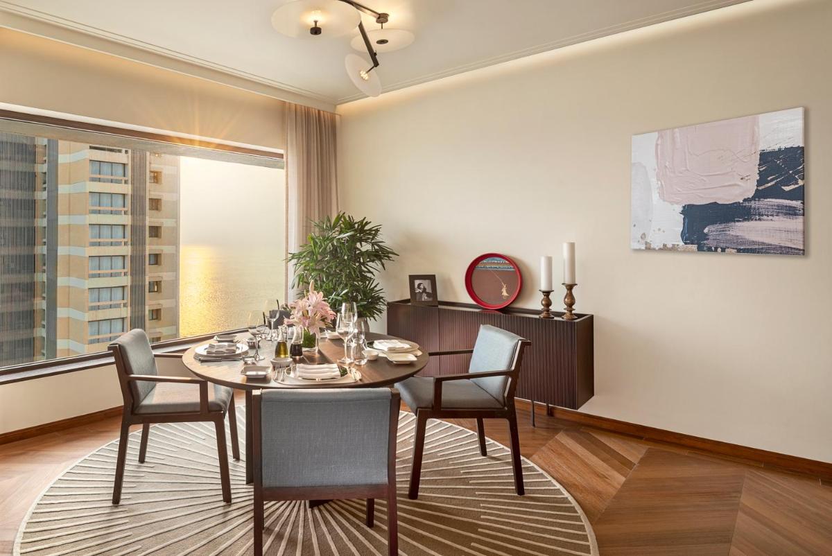 a dining room with a table and chairs and a window at The Oberoi Mumbai in Mumbai