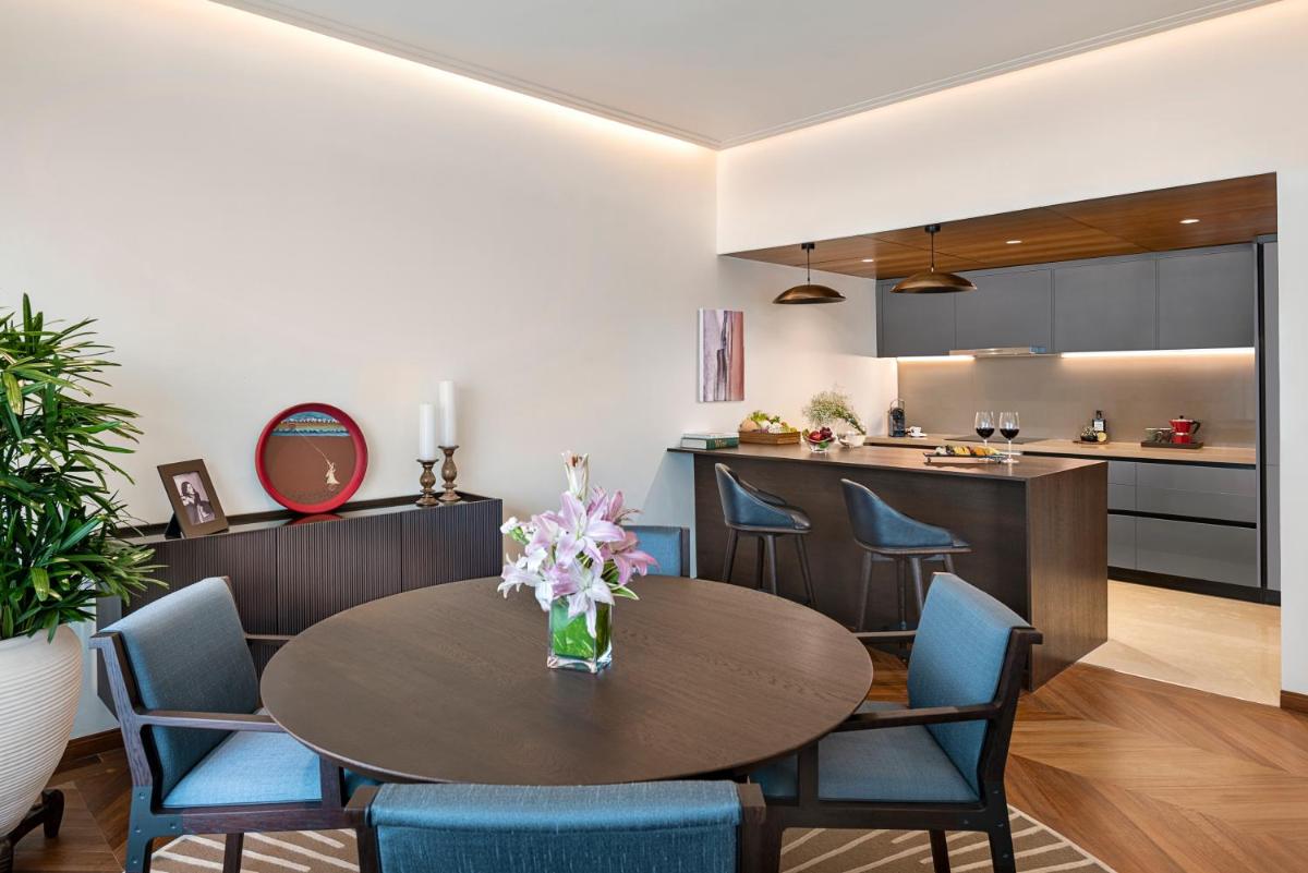 a kitchen and dining room with a table and chairs at The Oberoi Mumbai in Mumbai