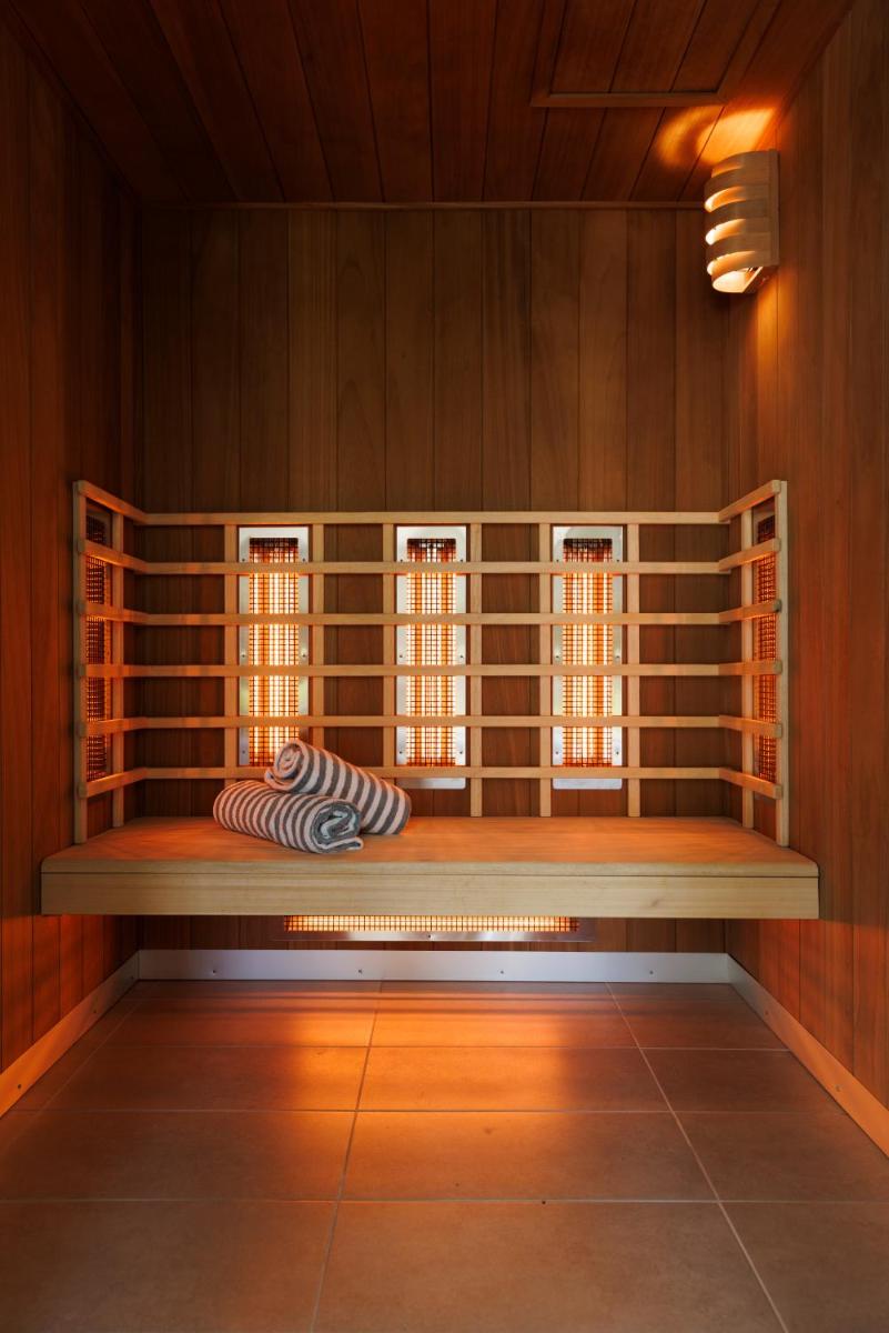 une pièce avec un banc dans un mur avec des fenêtres dans l'établissement Les Boréales - Appart'hotel & Restaurant, à Villers-sur-Mer