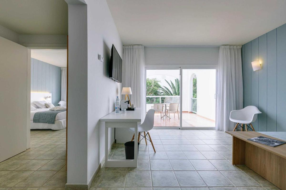 Un dormitorio con una cama y un escritorio en una habitación. en Alua Village Fuerteventura - All Inclusive, en Playa de Jandía