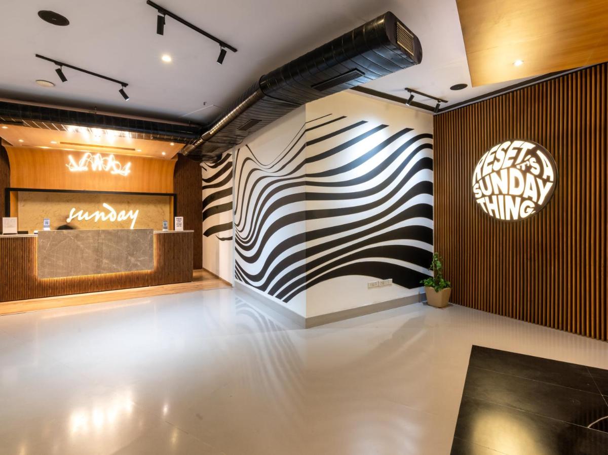 a lobby with a black and white striped wall at Sunday Hotel Chandigarh Zirakpur in Zirakpur